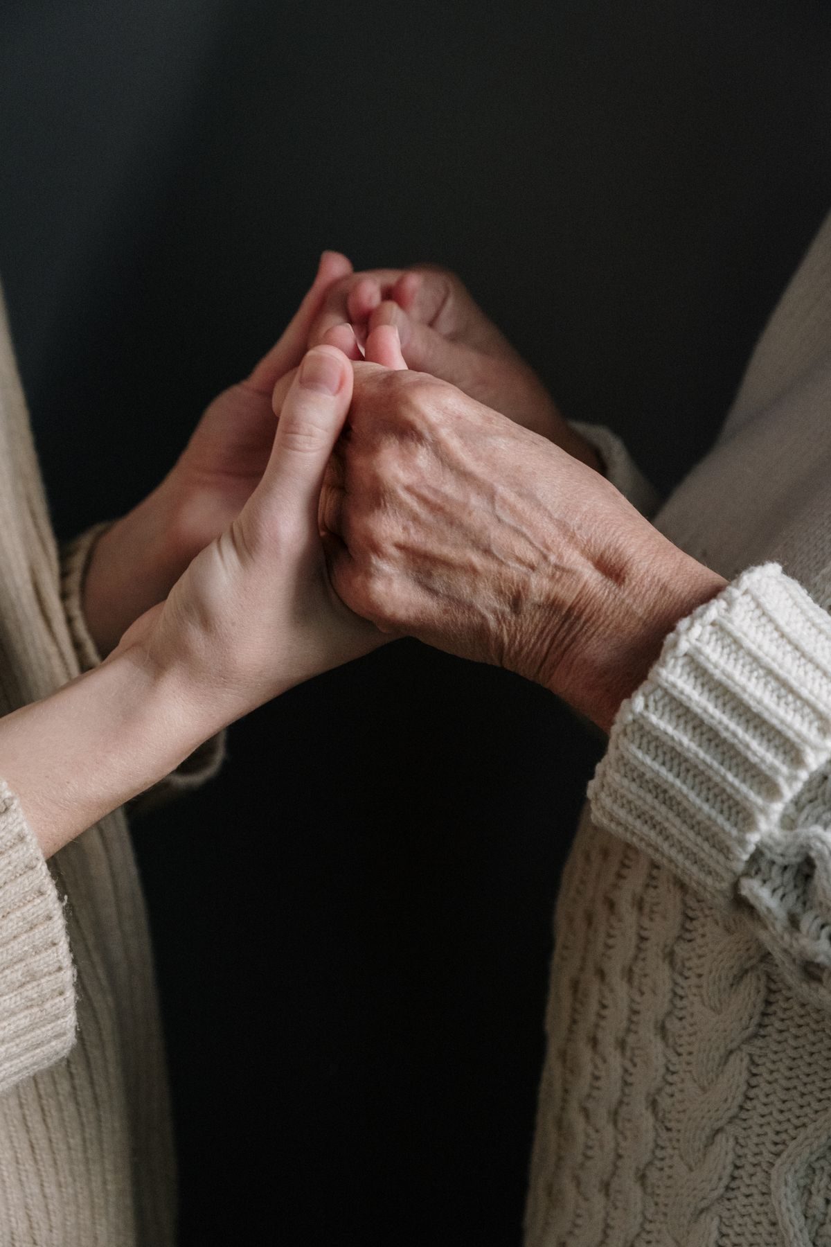 Mãos jovens e mãos idosas unidas em prece